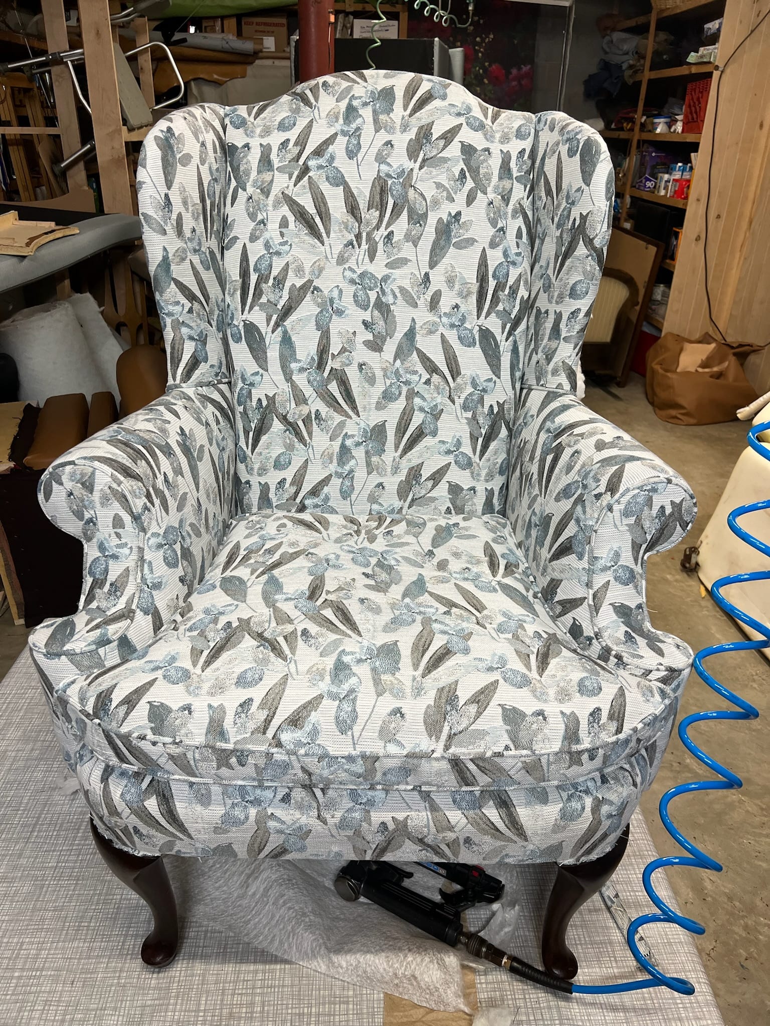 Patterned wingback chair reupholstered with new welt cording
